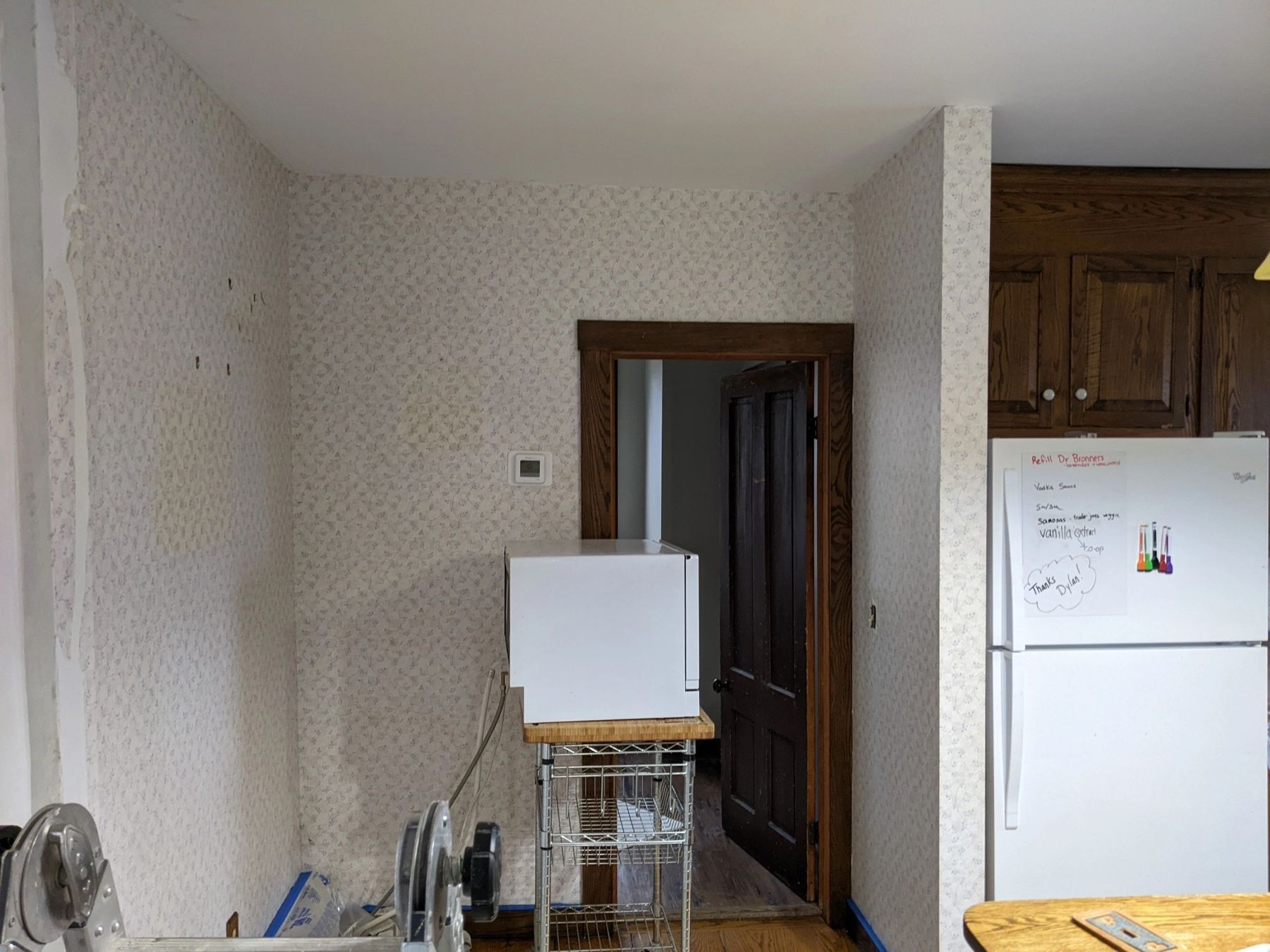 Kitchen with patterned wall finish and appliances during drywall patching