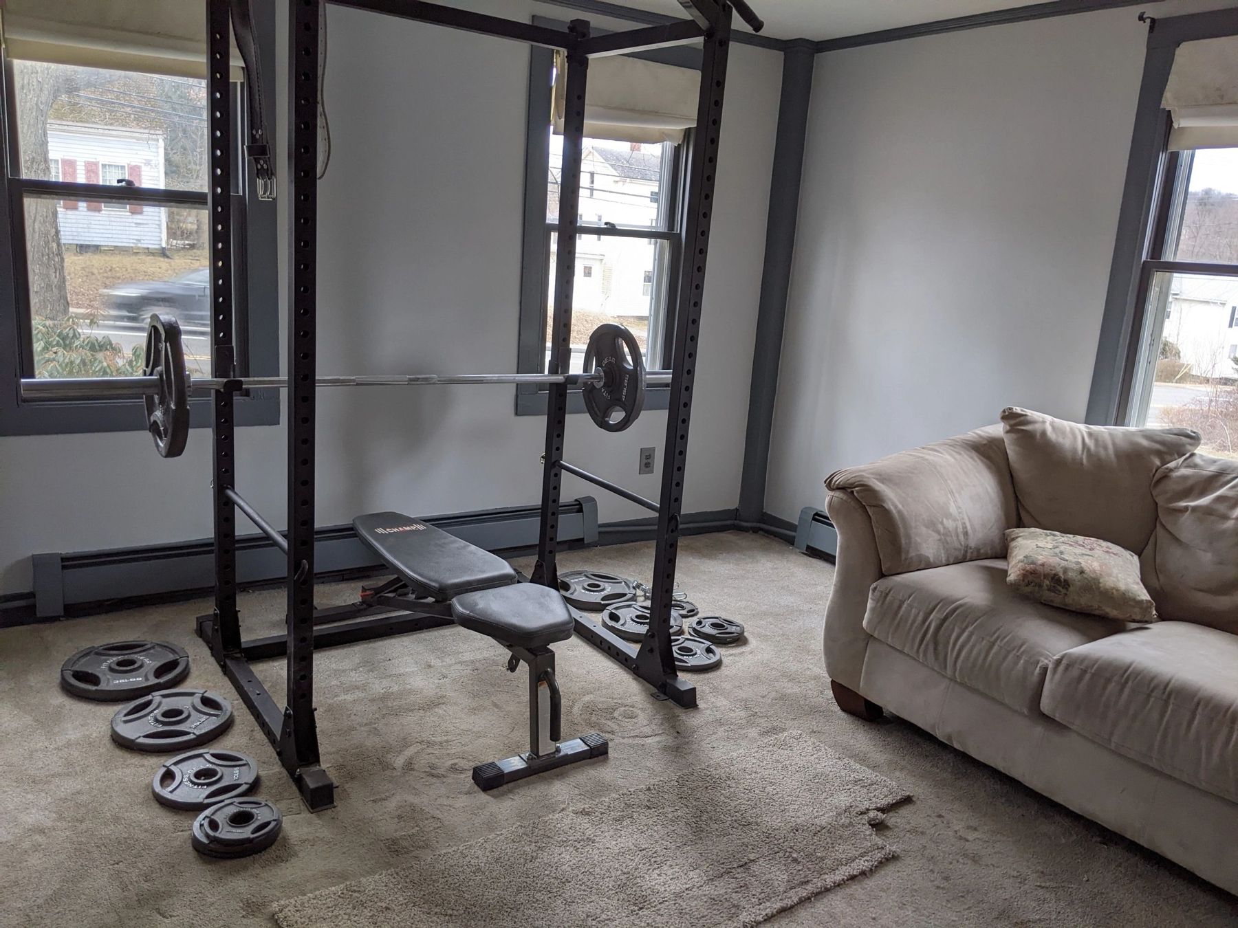Finished room with grey walls, home gym equipment and a couch