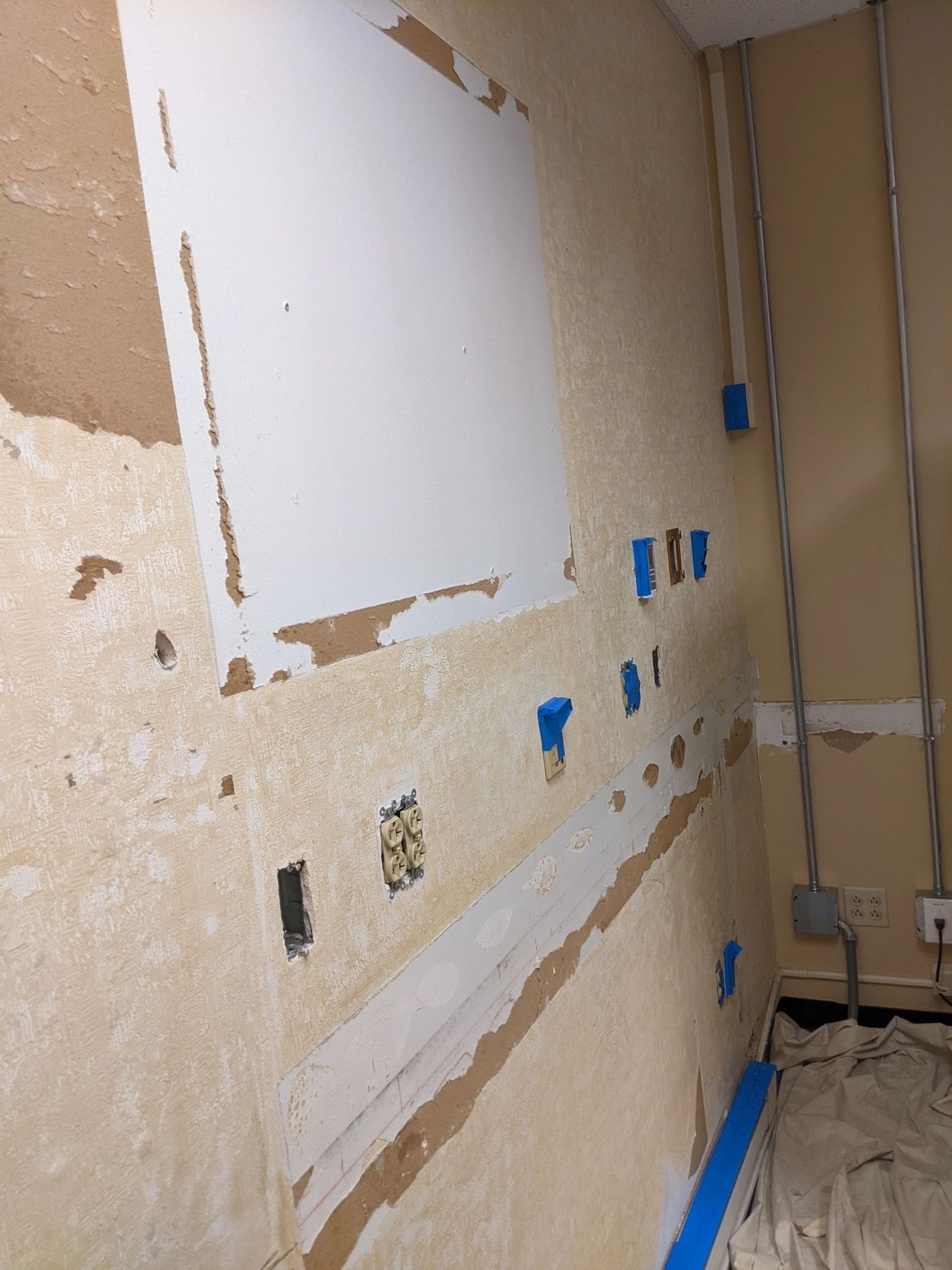 Wall opened up and taped off for fixture mounting and plumbing hookup