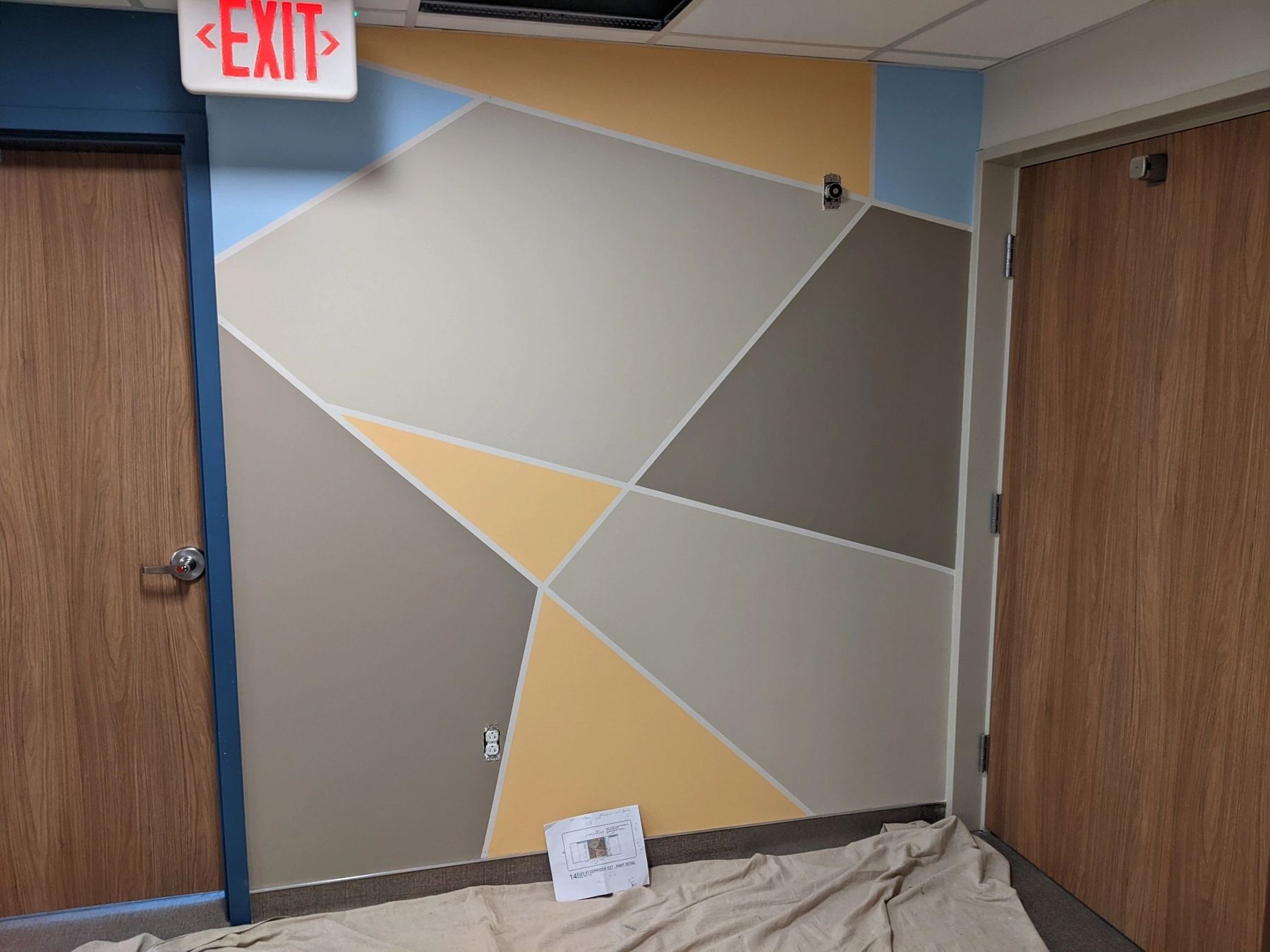 Commercial hallway wall finished with a geometric painted mural