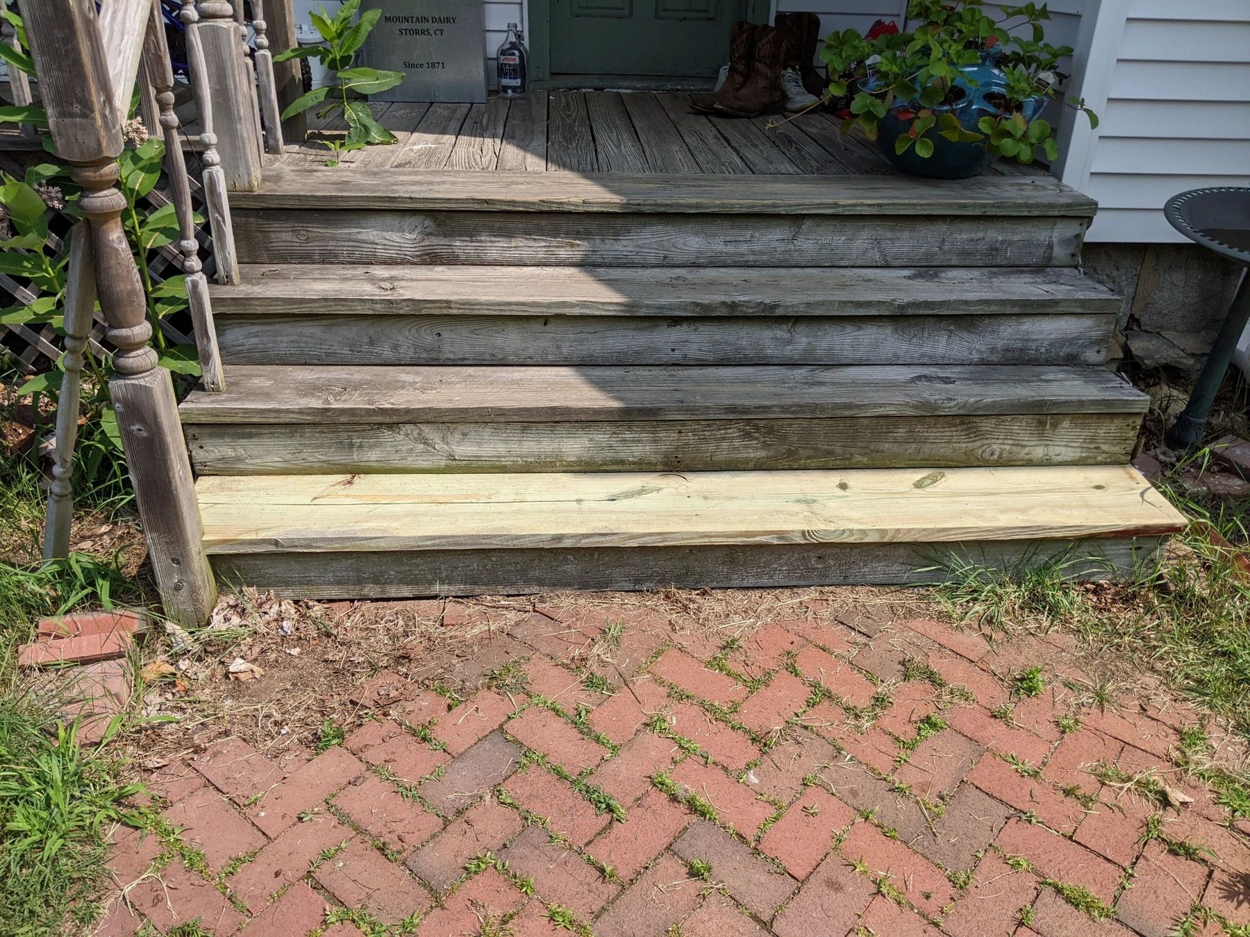 Rebuilt wooden steps leading down to a brick patio